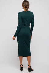 woman wearing a dark green ribbed midi dress with long sleeves and a fitted silhouette, view from the back