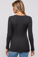 woman wearing a dark gray ribbed maternity top, showing the back view, paired with blue jeans