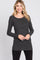 woman wearing a dark gray long sleeve ribbed top with a crossover design and a relaxed fit