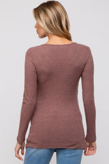 woman wearing a mauve long sleeve ribbed maternity top, showing a fitted design from the back