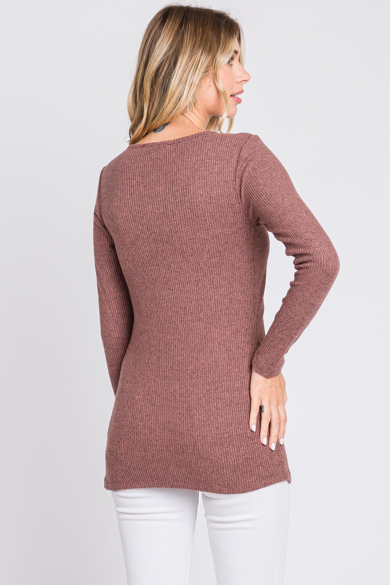 woman wearing a mauve ribbed long sleeve sweater, back view, paired with white pants