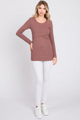 woman wearing a rust ribbed long sleeve top with a crossover design, paired with white leggings and white sneakers