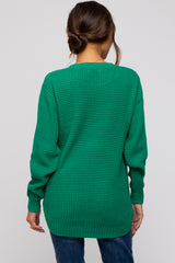 woman wearing a green oversized knit maternity sweater, styled with a relaxed fit and long sleeves