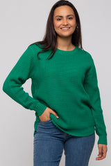woman wearing a green textured sweater with long sleeves and a relaxed fit, styled with blue jeans