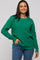 woman wearing a green textured sweater with long sleeves and a relaxed fit, styled with blue jeans