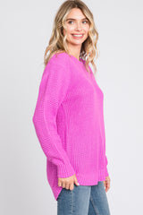 woman wearing a bright pink cozy knit sweater with a loose fit and side slits