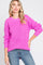 woman wearing a bright pink knit sweater with long sleeves and a relaxed fit, paired with blue jeans