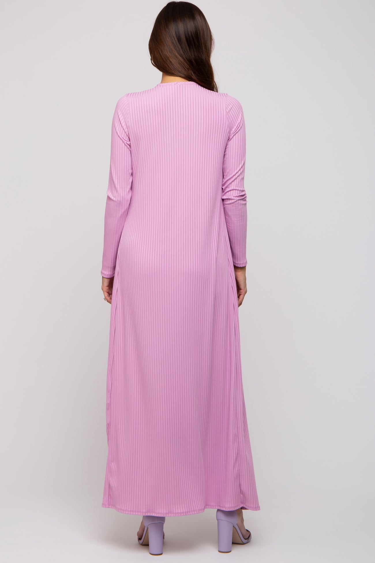 woman wearing a pink long sleeve maternity maxi dress with vertical stripes, back view