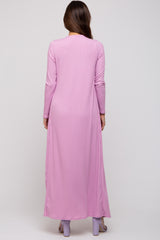 woman wearing a pink long sleeve maternity maxi dress with vertical stripes, back view