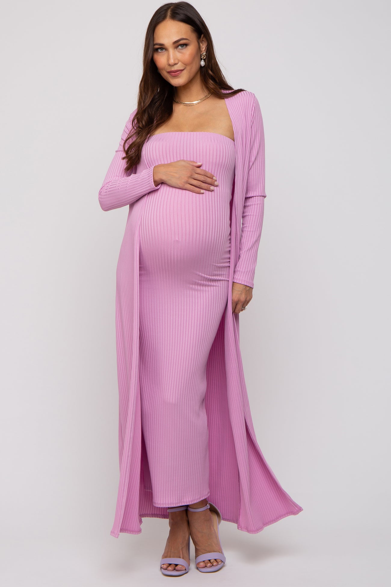 woman wearing a pink ribbed maternity dress with a fitted silhouette and long cardigan, displaying her baby bump