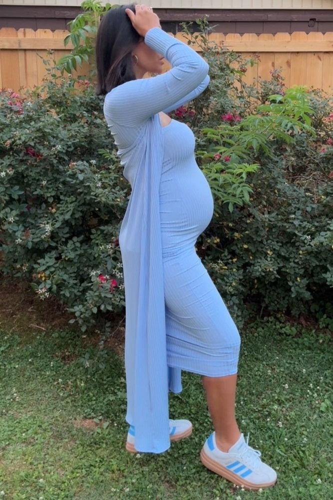 woman wearing a light blue ribbed maternity dress with a long cardigan and showcasing her baby bump