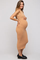 woman wearing a ribbed tan maternity dress and holding her baby bump