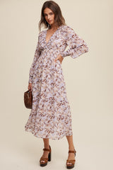 woman wearing a floral print long sleeve wrap dress with a deep V-neck and ruffled details