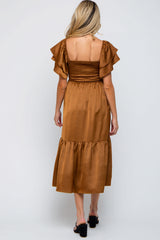 woman wearing a brown maternity dress with ruffled sleeves and a smocked bodice, showing a flowing skirt