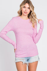 woman wearing a pink ribbed long sleeve top with scoop neckline and distressed denim shorts