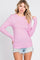 woman wearing a pink ribbed long sleeve top with scoop neckline and distressed denim shorts