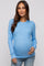 woman wearing a light blue ribbed maternity top and showing her baby bump