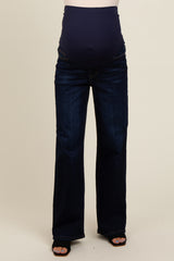 maternity wear dark wash bootcut jeans with a stretchy over-the-bump panel, model wearing them with black heels