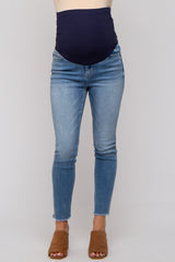 woman wearing a navy blue maternity belly band with light wash skinny jeans and brown slip-on sandals