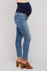 woman wearing light blue maternity jeans with a navy waistband and a visible baby bump