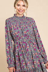 woman wearing a grey floral long sleeve dress with smocked bodice and ruffled hem