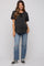 woman wearing a dark gray maternity t-shirt and distressed blue jeans, showing her baby bump