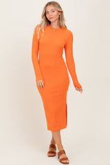 woman wearing a bright orange long sleeve ribbed midi dress with side slits and a fitted silhouette
