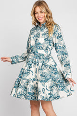woman wearing a blue and white floral long sleeve shirt dress with a tiered skirt and cinched waist