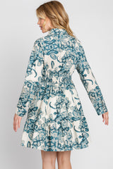 woman wearing a floral print long sleeve dress with a fitted waist and tiered skirt