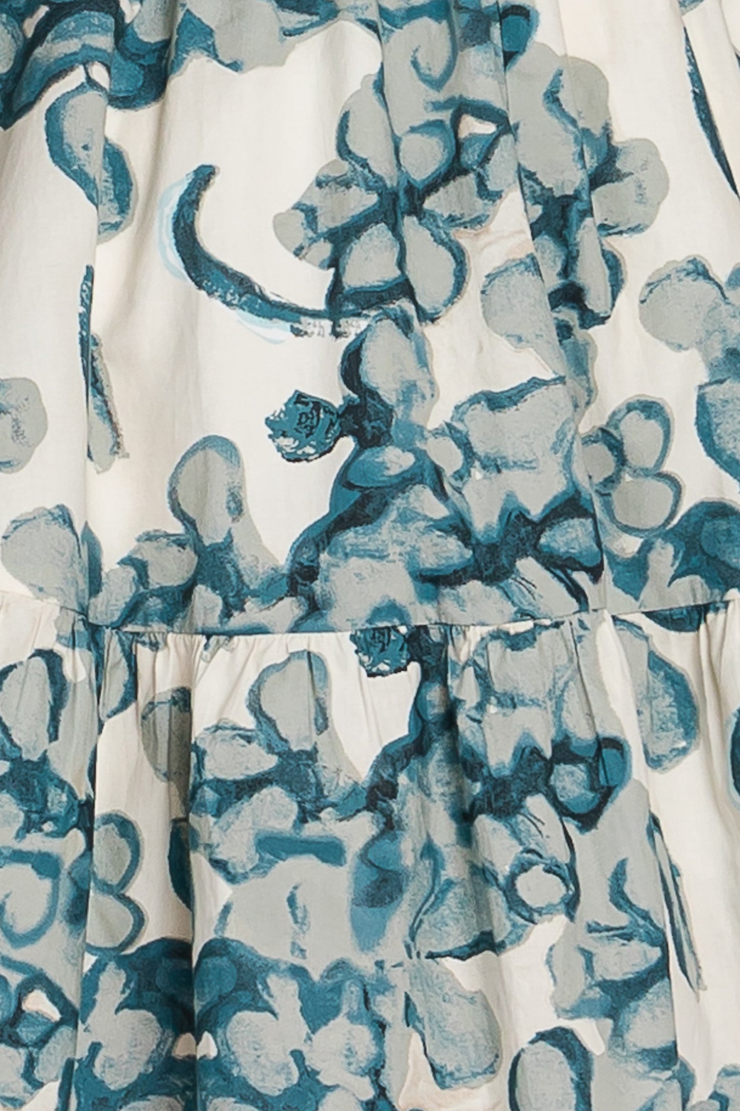 white dress with teal floral print and tiered ruffle detailing