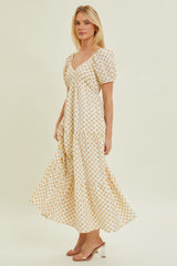 woman wearing a white and yellow floral print maxi dress with puff sleeves and a v-neckline