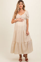woman wearing a white floral maternity maxi dress with puff sleeves and a baby bump visible