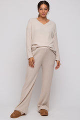 woman wearing a beige ribbed maternity sweater and matching wide-leg pants, featuring a v-neckline and relaxed fit