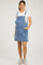 woman wearing a light blue denim maternity overall dress with pockets over a white t-shirt