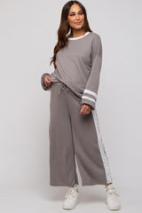 woman wearing a grey maternity loungewear set with long sleeves and wide leg pants featuring white side stripes