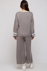 woman wearing a gray maternity loungewear set with white stripe details, showing a relaxed fit from the back