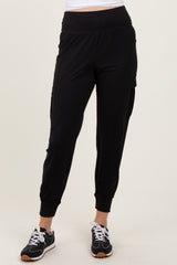 woman wearing black jogger pants with side pockets and cuffed ankles, paired with black sneakers