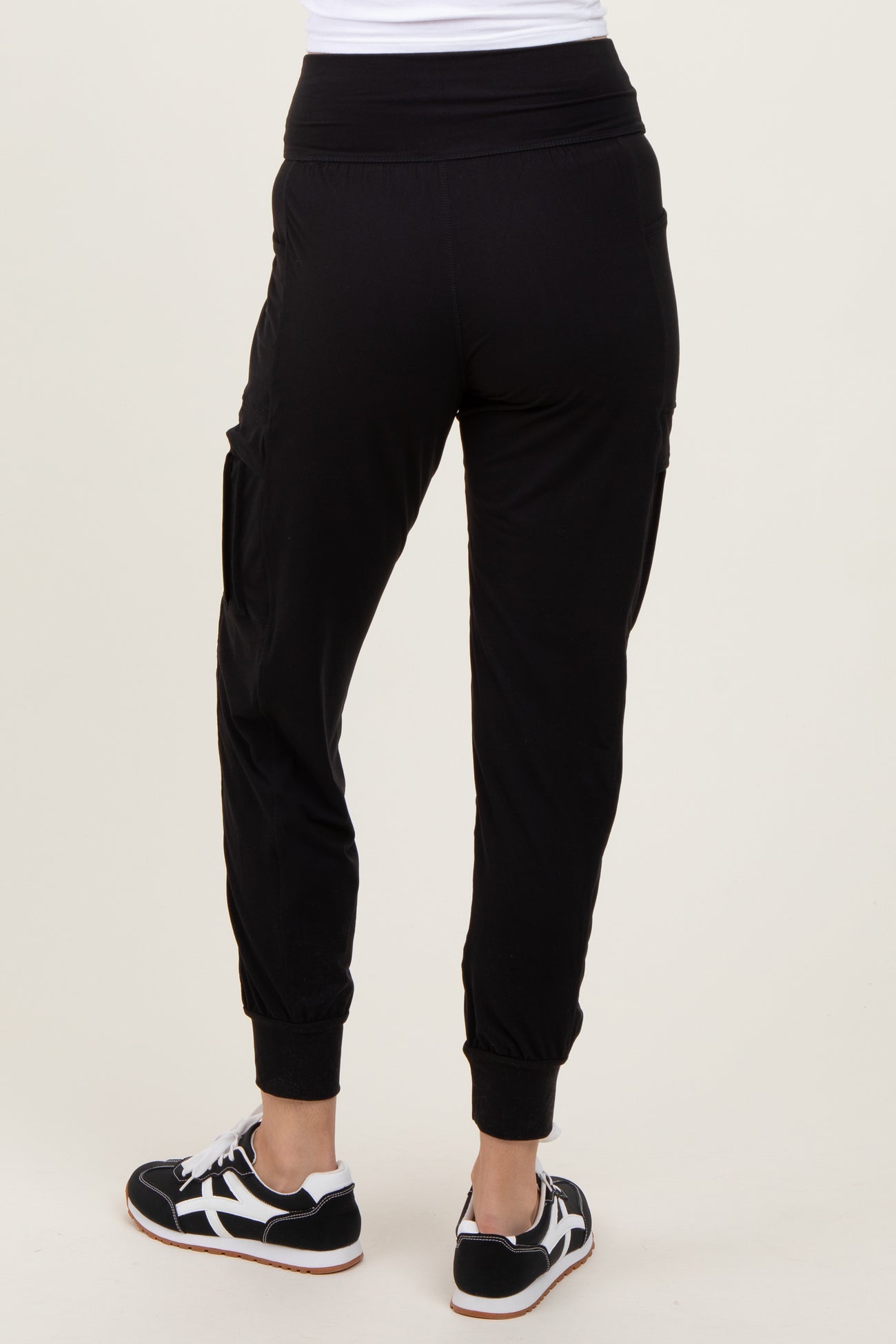 woman wearing black jogger pants with a relaxed fit and cropped cuffs, view from the back