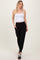 woman wearing a white fitted crop top and black tapered jogger pants with side pockets and cuffed ankles