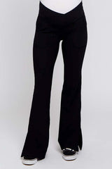 black maternity yoga pants with flared legs and front pockets, worn by a model with a visible baby bump