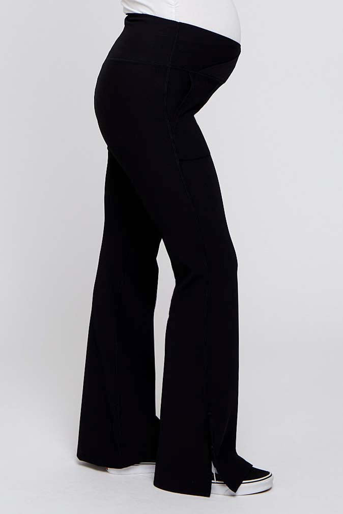 woman wearing black maternity pants with a flared leg and a stretchy waistband, showcasing a visible baby bump