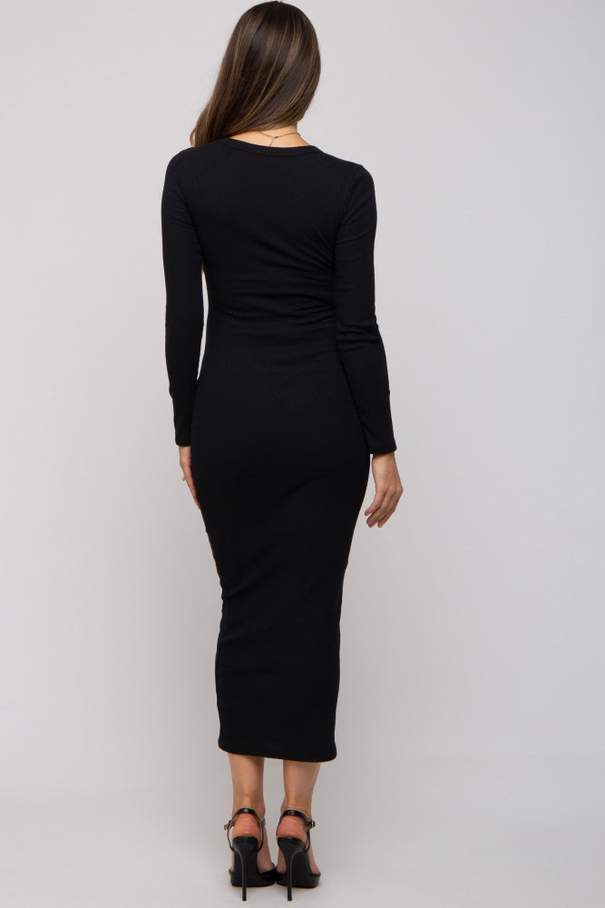 woman wearing a black long sleeve maternity dress with a fitted silhouette and mid-length hemline