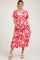 woman wearing a pink floral maternity dress with a v-neck and tiered skirt, holding her baby bump
