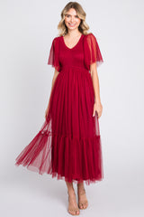 woman wearing a red dotted tulle maxi dress with flutter sleeves and a tiered skirt