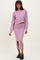 woman wearing a lavender cropped sweater and matching midi skirt with a front slit