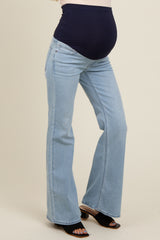 woman wearing light blue maternity flared jeans with a black over-the-bump waistband and visible baby bump