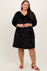 woman wearing a black velvet plus-size dress with three-quarter sleeves and a v-neckline