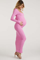 woman wearing a fitted pink long sleeve maternity dress, highlighting her baby bump