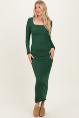 woman wearing a green long sleeve form-fitting maxi dress with a square neckline