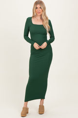 woman wearing a long sleeve emerald green ribbed maxi dress with a square neckline and a form-fitting silhouette